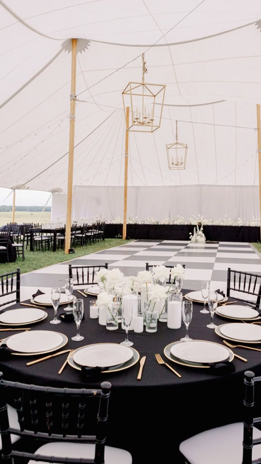 Elegant black wedding decor underneath a sailcloth tent.