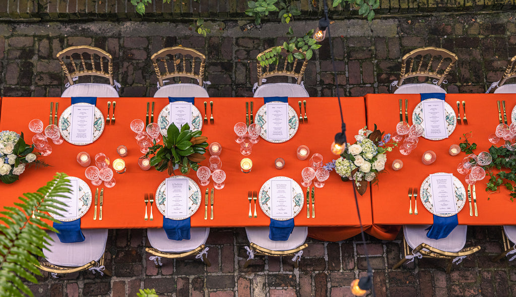 A beautiful table showing place settings and gold flatware available for rental.